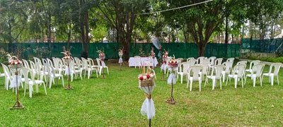 Jardín Principal con sillas blancas y arreglos florales sobre el césped para ceremonia